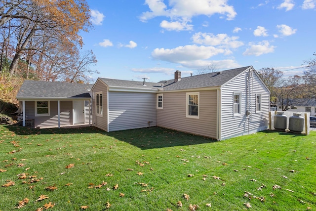 rear view of property with a yard