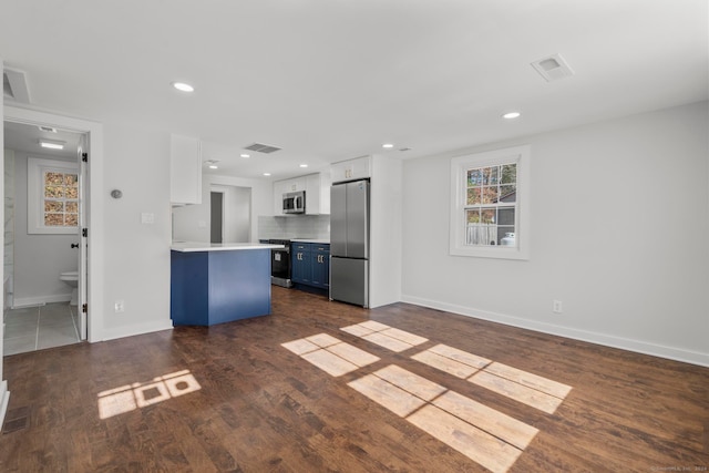 kitchen featuring white cabinetry, appliances with stainless steel finishes, dark hardwood / wood-style flooring, a kitchen breakfast bar, and blue cabinets