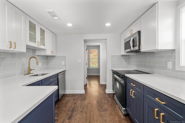 kitchen with dark hardwood / wood-style floors, white cabinetry, sink, and appliances with stainless steel finishes