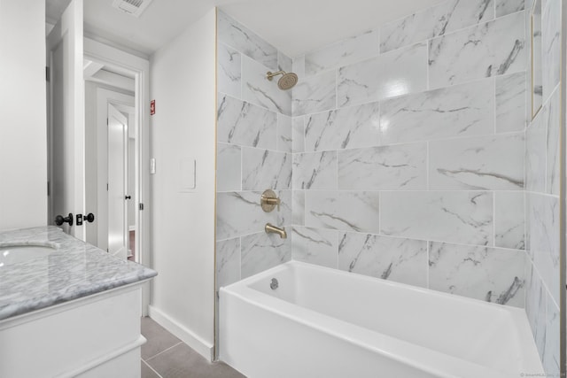 bathroom with tile patterned flooring, vanity, and tiled shower / bath combo