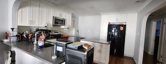 kitchen featuring crown molding, white cabinets, kitchen peninsula, and stainless steel appliances