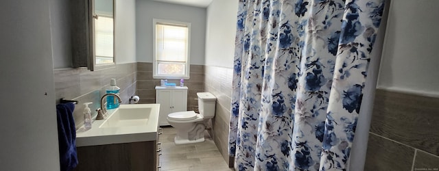 bathroom with vanity, toilet, tile walls, and a shower with curtain