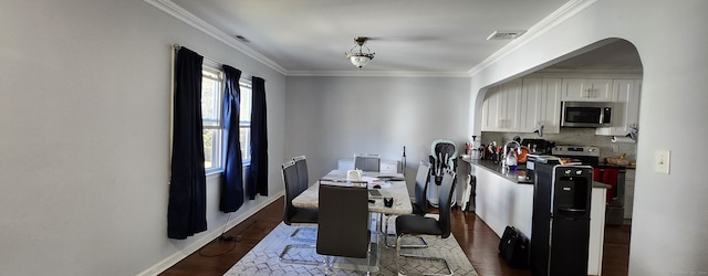 dining space featuring ornamental molding and dark hardwood / wood-style floors