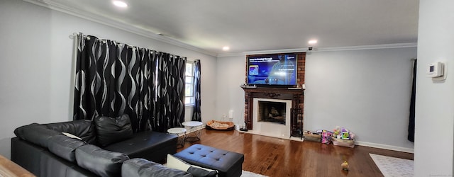 living room with crown molding, a fireplace, and hardwood / wood-style floors