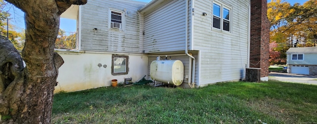 rear view of property featuring a lawn and a garage