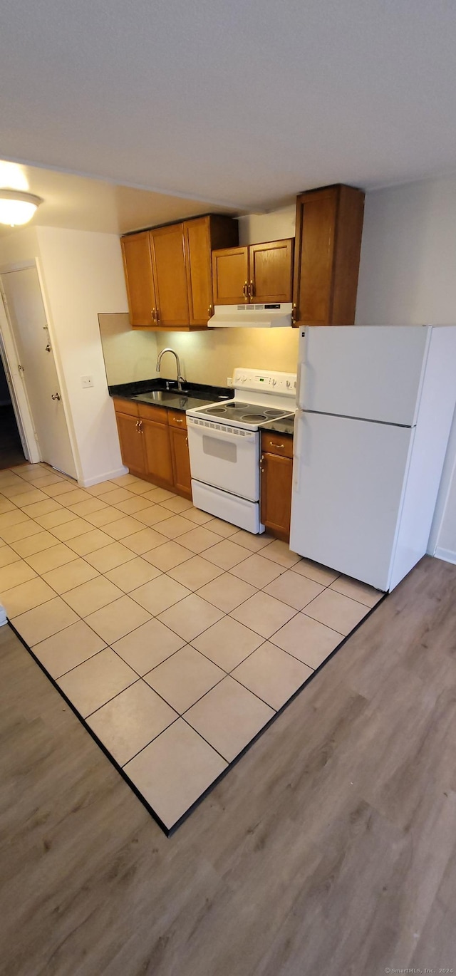 kitchen with white appliances, light hardwood / wood-style flooring, and sink