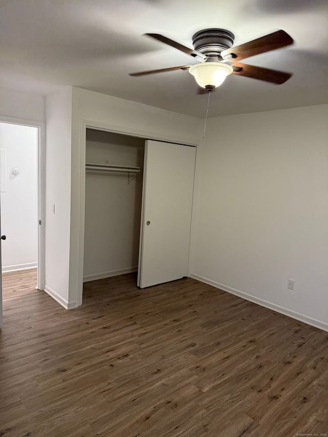 unfurnished bedroom with dark hardwood / wood-style flooring, ceiling fan, and a closet