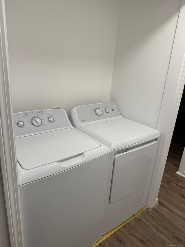 washroom with dark wood-type flooring and washer and dryer