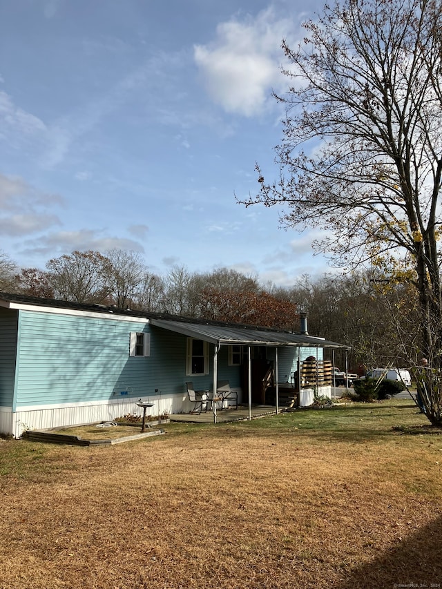 back of house featuring a patio and a yard