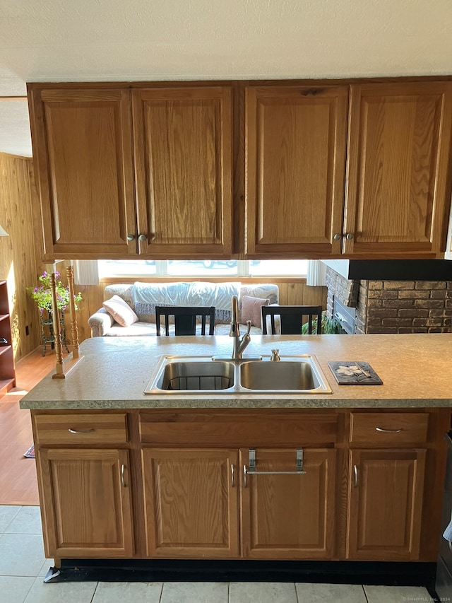 kitchen featuring wood walls, sink, and light tile patterned flooring