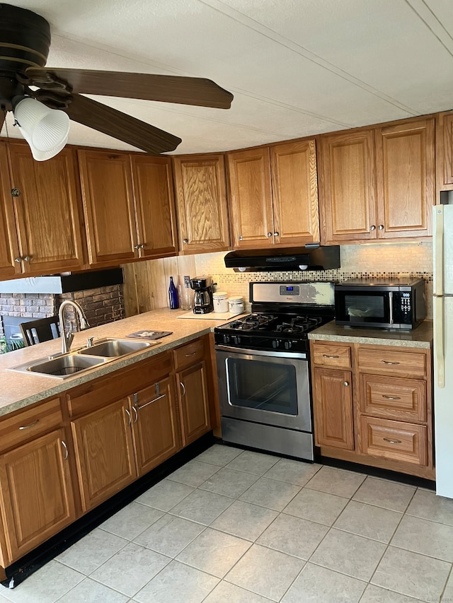 kitchen with stainless steel appliances, light tile patterned floors, sink, and backsplash