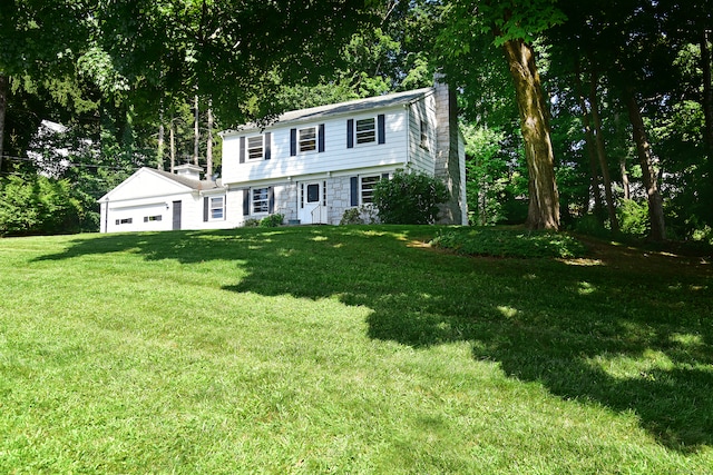 colonial inspired home with a front lawn and a garage