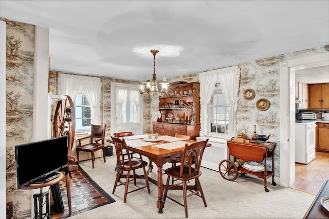 dining space with a chandelier and light hardwood / wood-style floors