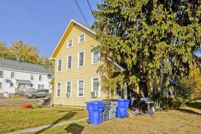 back of property with a lawn and cooling unit