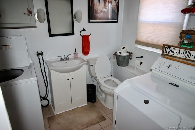 bathroom featuring toilet, vanity, washer / clothes dryer, and tile patterned floors