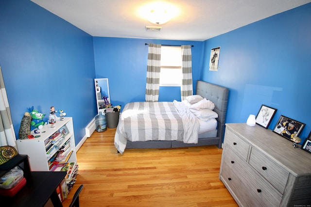 bedroom featuring a baseboard radiator and light hardwood / wood-style flooring