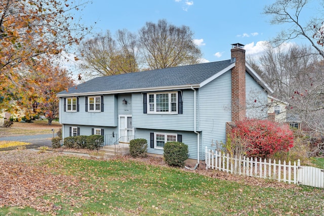 raised ranch featuring a front lawn