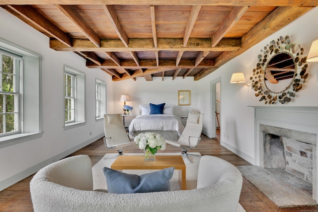 bedroom featuring a wood ceiling with exposed beams, multiple windows, a premium fireplace, and wood finished floors