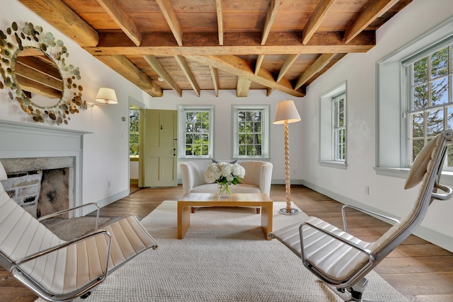 living area featuring a wooden ceiling with exposed beams, hardwood / wood-style floors, and a high end fireplace