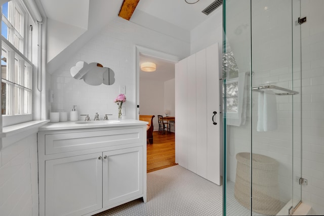 full bath with tile walls, a shower stall, vanity, and tile patterned flooring