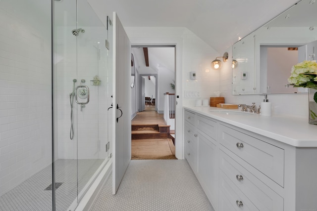 full bathroom featuring vanity, lofted ceiling, a shower stall, and tile patterned floors