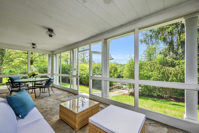 sunroom / solarium featuring wood ceiling and stone finish floors