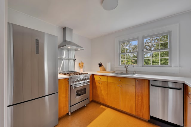 kitchen with stainless steel appliances, wall chimney exhaust hood, light countertops, and brown cabinetry