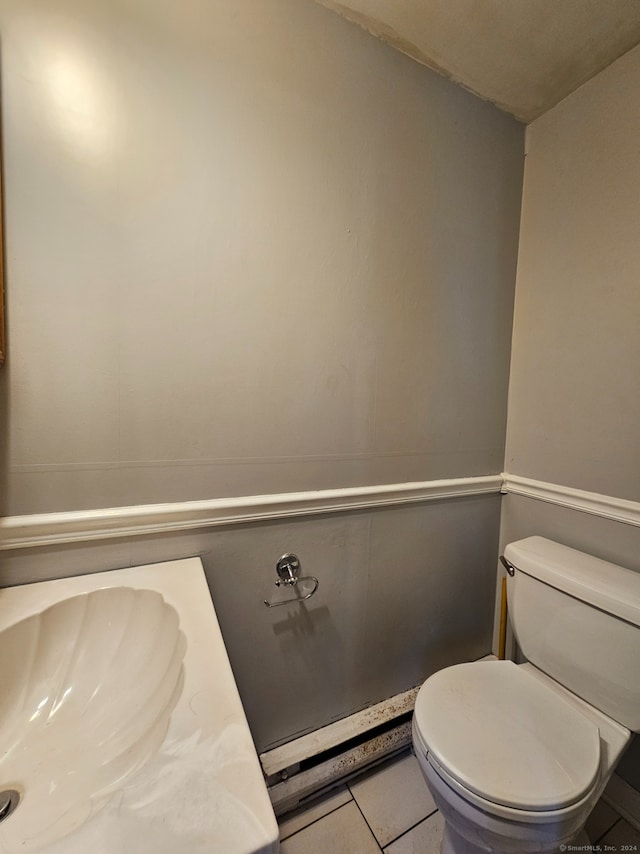 bathroom with toilet, vanity, and tile patterned flooring