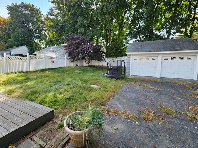 view of yard featuring a garage and a trampoline