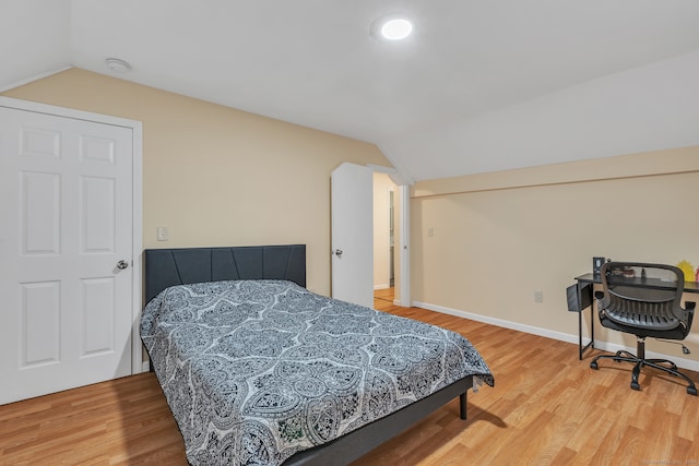 bedroom with lofted ceiling and hardwood / wood-style flooring