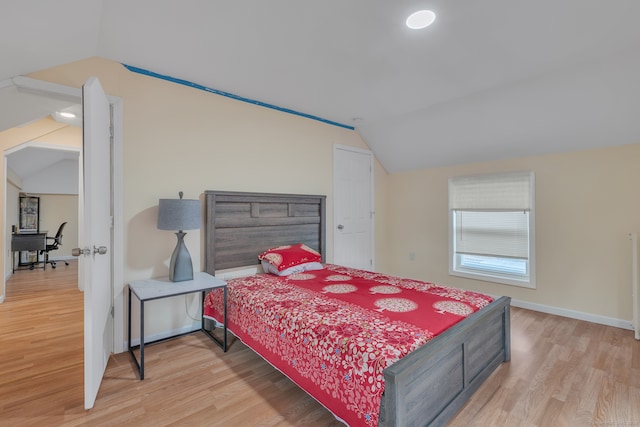 bedroom with light hardwood / wood-style floors and lofted ceiling