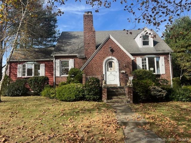 39 Rockefeller Ave, West Haven, CT 06516 - tudor house featuring brick siding, a chimney, and a front lawn