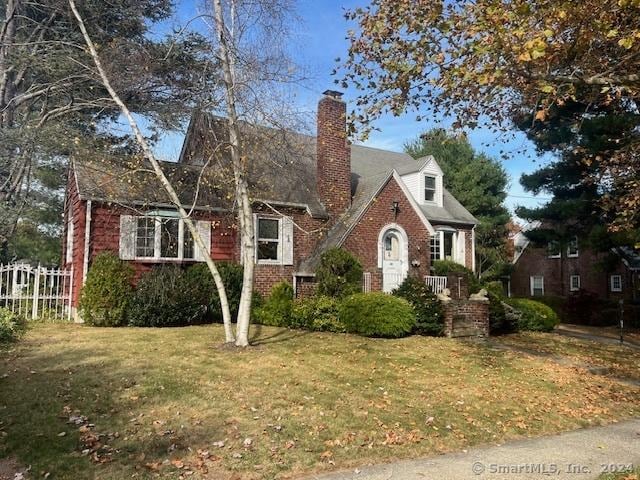 39 Rockefeller Ave, West Haven, CT 06516 - view of front facade with brick siding, a front yard, and a chimney