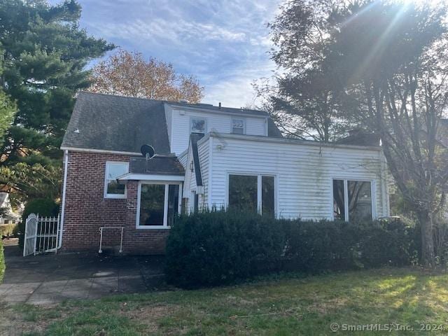 39 Rockefeller Ave, West Haven, CT 06516 - rear view of property featuring brick siding, a patio area, and a yard