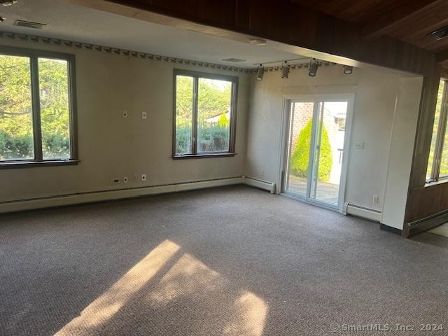 39 Rockefeller Ave, West Haven, CT 06516 - carpeted empty room with a baseboard radiator, rail lighting, and beam ceiling