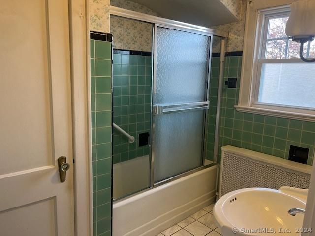 39 Rockefeller Ave, West Haven, CT 06516 - full bath with tile patterned floors, bath / shower combo with glass door, and tile walls