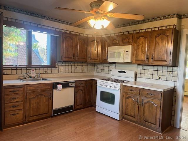 39 Rockefeller Ave, West Haven, CT 06516 - kitchen featuring white appliances, a sink, light countertops, decorative backsplash, and light wood finished floors