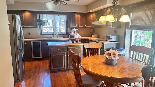 kitchen featuring dark brown cabinetry, stainless steel fridge with ice dispenser, sink, and dark wood-type flooring