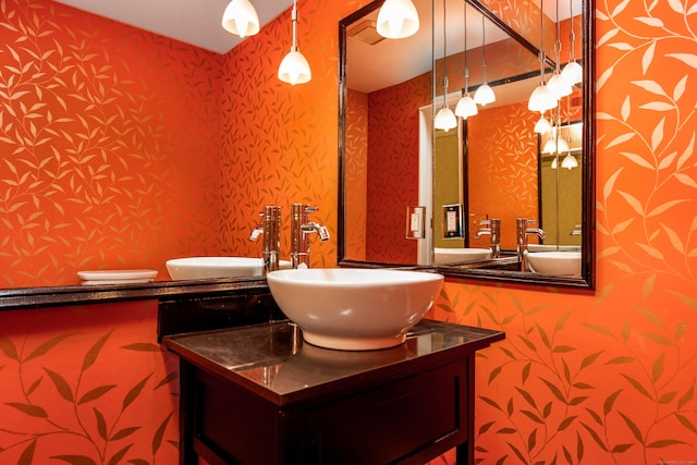 bathroom featuring wallpapered walls and vanity