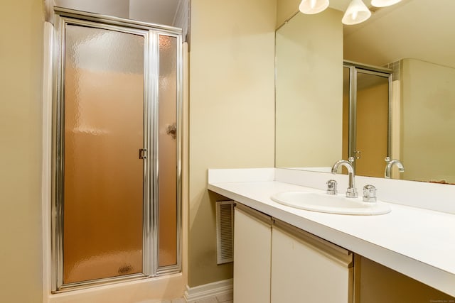 full bathroom with vanity, a shower stall, and visible vents