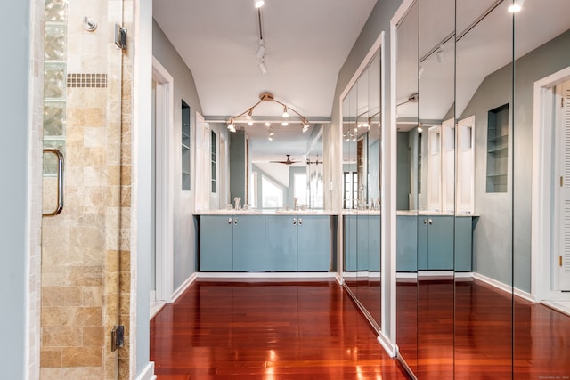 hallway featuring lofted ceiling, sink, track lighting, and dark hardwood / wood-style floors