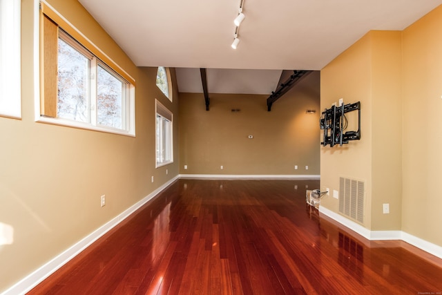 unfurnished room featuring wood finished floors, visible vents, and baseboards