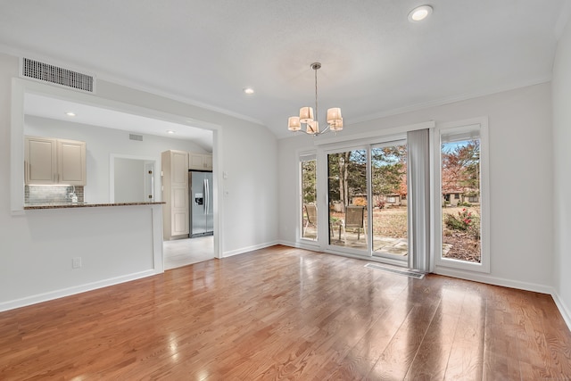 interior space with an inviting chandelier, light hardwood / wood-style floors, and crown molding