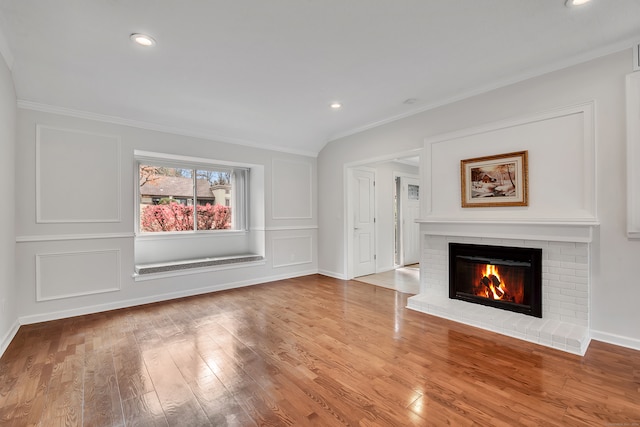 unfurnished living room with a fireplace, light wood-type flooring, and ornamental molding