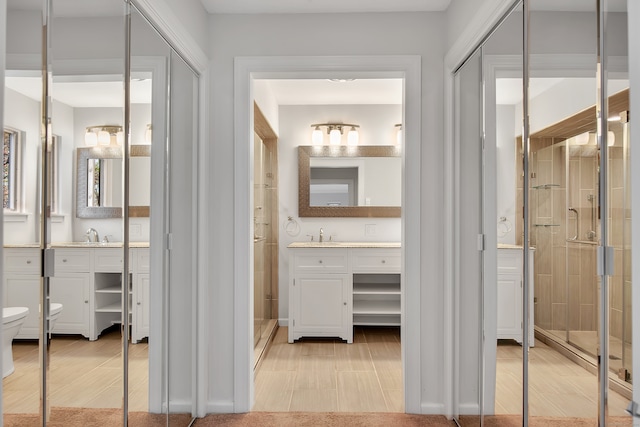 bathroom with walk in shower, vanity, toilet, and hardwood / wood-style flooring