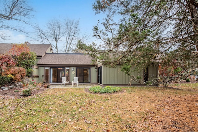 rear view of house featuring a patio and a yard