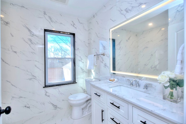 bathroom featuring vanity, toilet, and tile walls