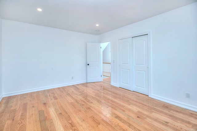 unfurnished bedroom featuring light hardwood / wood-style floors and a closet