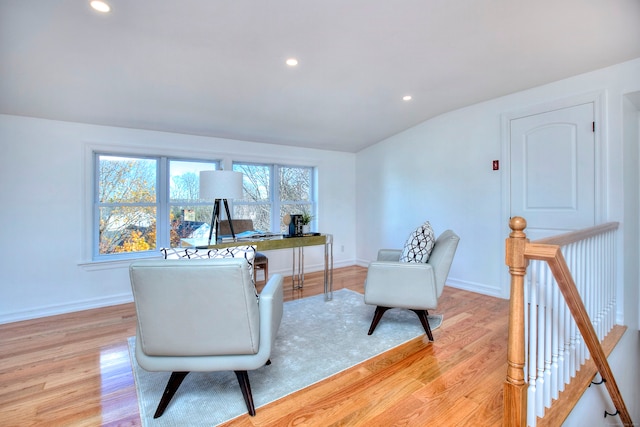 home office with light hardwood / wood-style flooring and lofted ceiling