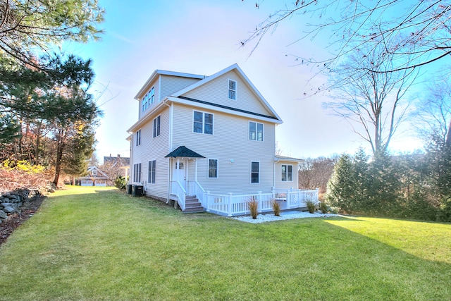 rear view of house with a yard and central AC unit